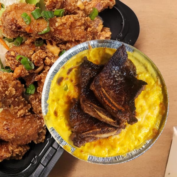 Crispy fried chicken with green onions and a side of mac and cheese topped with short ribs.
