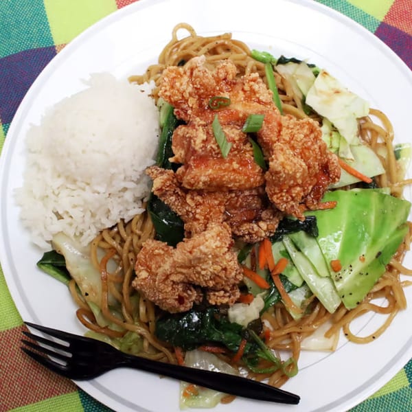Hawaiian plate lunch with crispy fried chicken, noodles, vegetables, and white rice.